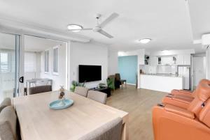 a living room with a couch and a dining room table at McLeod Rise - Cairn Base with Rooftop Pool & Spa in Cairns +18 photos