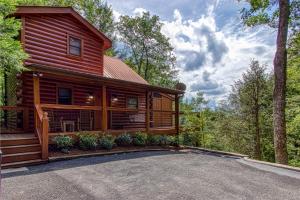 a log cabin in the woods with a driveway at Mountain Dreams in Sevierville