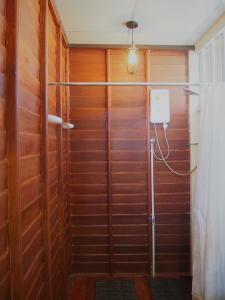 a shower in a room with wooden walls at U Pae PaeStay Uthaithani in Uthai Thani