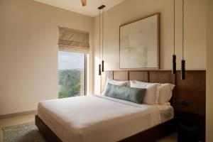 a bedroom with a large bed with a window at Southbeach Weligama in Weligama