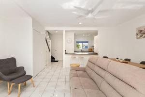a living room with a couch and a kitchen at Tropical Cove at Trinity Beach with Lagoon Pool in Trinity Beach
