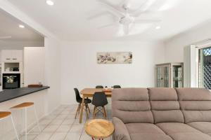 a living room with a couch and a table at Tropical Cove at Trinity Beach with Lagoon Pool in Trinity Beach