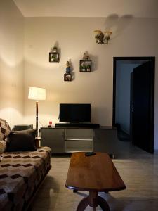a living room with a couch and a table at Payaringal House Botanical Garden White Town Promenade Beach in Pondicherry