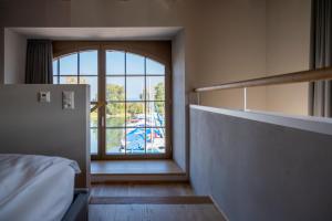 a room with a bed and a large window at LAKE-LOFT APARTMENT's direkt im Hafen in Romanshorn