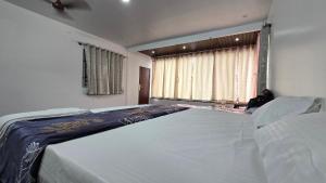 a large bed in a bedroom with a window at Sunrise Inn in Yelagiri