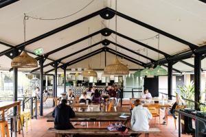 a group of people sitting at tables in a restaurant at YHA Byron Bay in Byron Bay