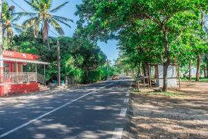 an empty street with trees on the side of the road at Maison Belle Vue in Le Morne