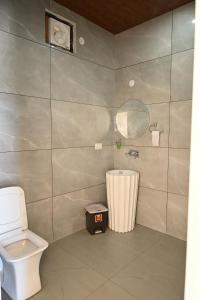 a bathroom with a toilet and a trash can at Hotel Tela Suite Near IGI Airport Delhi in New Delhi