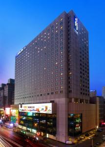 a tall building with cars parked in front of it at JEN Shenyang by Shangri-La in Shenyang