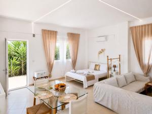 a white living room with a couch and a table at Studio Malades, Heraklion in Maládhes