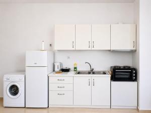 a white kitchen with a sink and a refrigerator at Studio Malades, Heraklion in Maládhes