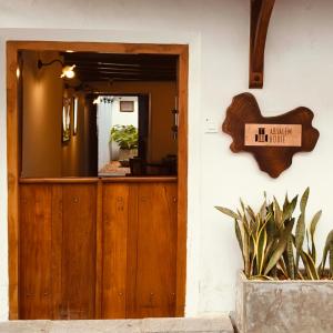 a wooden door with a sign that reads he only fit inside at Ezekiel House Residence in Cochin