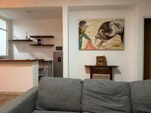 a living room with a couch and a painting on the wall at Casa Dixam Luum in Puerto Morelos