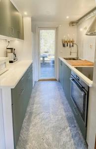 a kitchen with blue cabinets and a window at Nature And Veranda In Perfect Alignment in Djurhamn