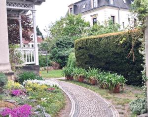 a garden with a cobblestone path in front of a house at Villa Taxus-Smokers not welcome in Dresden