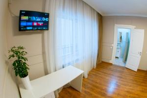 a living room with a white bench and a tv on the wall at Обійми Embrace in Truskavets