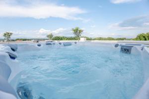 a jacuzzi tub with blue water on top of it at Penthouse Olivia Sky Residence in Međugorje