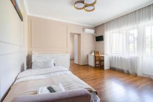 a bedroom with a bed and a desk in it at Обійми Embrace in Truskavets
