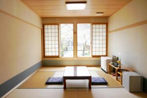 a living room with a table and a window at Katakuri no Yado in Tsunan