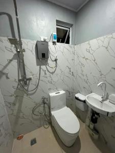 ein Badezimmer mit Toilette und Waschbecken in der Unterkunft A Residences in Daet