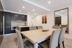a kitchen and dining room with a wooden table and chairs at Poolside Relaxation - Resort Retreat with Beach Access in Port Douglas