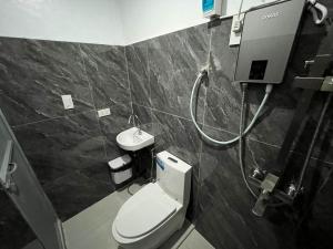 ein Badezimmer mit Toilette und Dusche in der Unterkunft A Residences in Daet