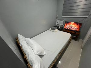 ein kleines Schlafzimmer mit Bett und Fernseher in der Unterkunft A Residences in Daet