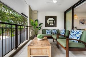 a living room with a couch and a table at Rooftop Tranquility at Stunning Temple Resort in Port Douglas