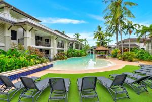 a resort pool with chairs and a gazebo at Rooftop Tranquility at Stunning Temple Resort in Port Douglas