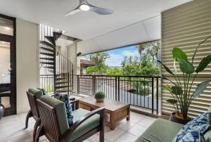 a living room with a balcony with a table and chairs at Rooftop Tranquility at Stunning Temple Resort in Port Douglas +34 photos