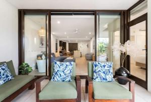 a living room with two chairs and a couch at Rooftop Tranquility at Stunning Temple Resort in Port Douglas