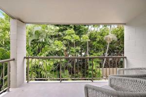 an open balcony with chairs and trees at The Tropical Trinity - A Breezy Beachside Getaway in Trinity Beach +13 photos