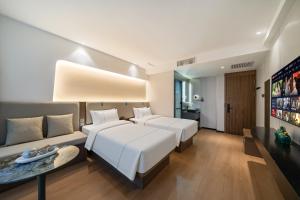 a hotel room with two beds and a tv at 德全m酒店 in Beijing