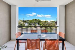 a patio with a table and chairs on a balcony at The Loft - Trendy Coastal Charm with Pool in Cairns