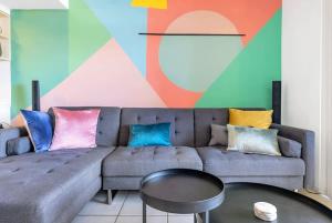 a living room with a gray couch with colorful pillows at The Loft - Trendy Coastal Charm with Pool in Cairns +30 photos