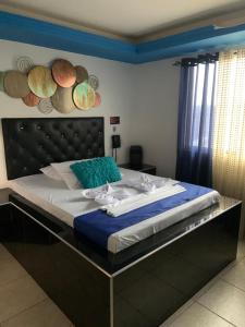 a large bed in a bedroom with a black headboard at Hotel Rio Sol in Cali