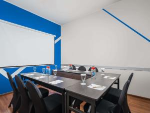 a room with a table and chairs and a large window at Ibis Budget Jakarta Menteng in Jakarta