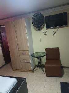 a bedroom with a table and a chair and a tv at Hotel Rio Sol in Cali