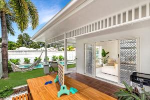 a house with a porch with a hammock and a pool at The Bird House - Poolside Haven a Stroll from Beach in Palm Cove