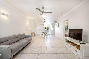 a living room with a couch and a tv at Trinity Beach Bliss - Experience Tropical Living in Trinity Beach +19 photos