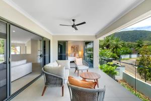 an open living room with a balcony with a couch and a table at The Elysian at Argentea - Beachside Stay with Pool in Palm Cove