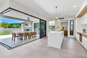 a kitchen and dining room with a table and chairs at The Elysian at Argentea - Beachside Stay with Pool in Palm Cove