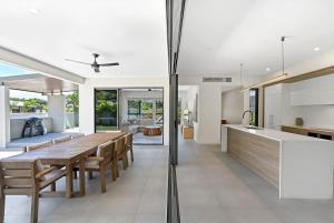an open kitchen and dining room with a wooden table at The Elysian at Argentea - Beachside Stay with Pool in Palm Cove +30 photos