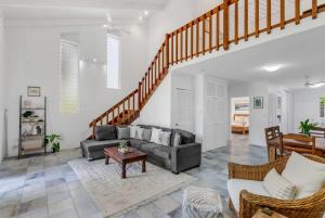 a living room with a couch and a staircase at Nirvana - Steps to Four Mile Beach with Shared Pool in Port Douglas