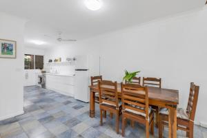 a kitchen and dining room with a wooden table and chairs at Nirvana - Steps to Four Mile Beach with Shared Pool in Port Douglas +25 photos