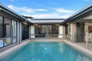 an empty swimming pool in a house with windows at Trinity Beach Oasis - Poolside Retreat and Serenity in Trinity Beach