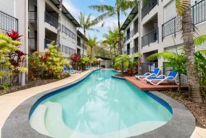 a swimming pool at a resort with lounge chairs at Lagoon Lookout - Poolside Studio near Trinity Beach in Trinity Beach