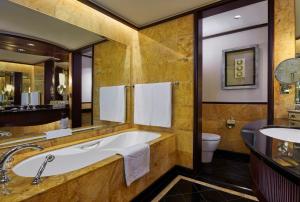 a bathroom with a tub and a toilet and a sink at Mandarin Oriental, Kuala Lumpur in Kuala Lumpur
