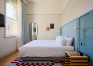 a bedroom with a large white bed and a window at Owston Hotel in Fremantle