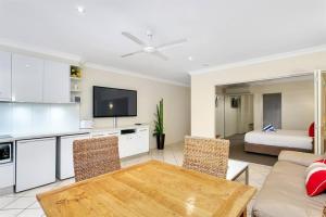 a living room with a couch and a table and a bed at Escape for Two - A Boutique Tropical Treasure in Port Douglas